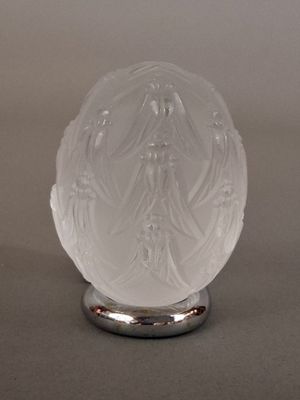 une image représentant une boule de verre posée sur un socle métallique