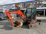 a small excavator that is parked in front of a building