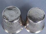 pair of silver plated salt and pepper shakers on a blue background
