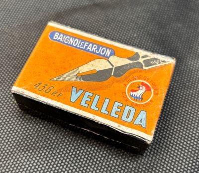 a small match box with a pair of scissors on it