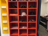 une bibliothèque rouge sur laquelle sont posés tout un tas de chapeaux