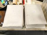 deux morceaux de tissu blanc posés sur une table, à côté d'une paire de ciseaux