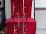 a metal shelf with a red table cloth on it
