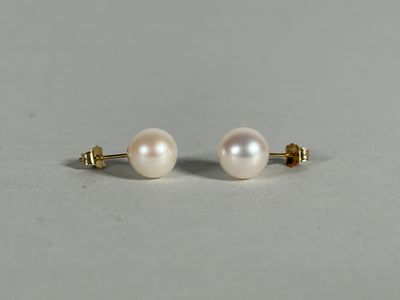 a pair of pearl earrings on a white surface