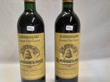 two bottles of wine sitting next to each other on a table
