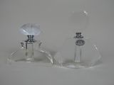 une paire de flacons de parfum en verre transparent posés sur une surface blanche