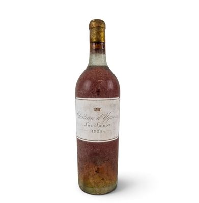 an old bottle of wine sitting on top of a white surface