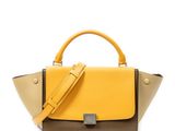 a yellow and brown handbag sitting on top of a white surface