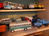 de nombreuses petites voitures et camions sur une étagère dans une pièce