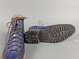 pair of blue leather boots with laces on them on a gray surface