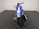 a blue and white motorcycle parked on a black and white checkered floor