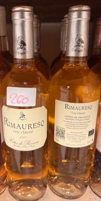 plusieurs bouteilles de vin sont alignées sur une étagère dans un magasin