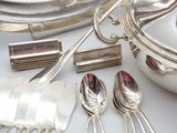 a silver plate with silver spoons and silverware on it