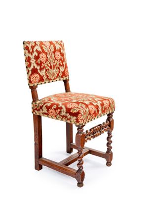 une image représentant une chaise en bois dont l'assise est recouverte d'un tissu rouge et or