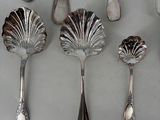 six spoons and two spoons are lined up on a table