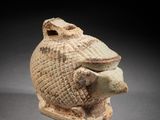 une vieille figurine en argile représentant une tête sur laquelle est perché un oiseau