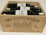 six bottles of wine in a wooden box on a table