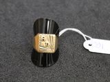 a black and gold ring with a tag on it