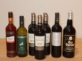plusieurs bouteilles de vin sont alignées sur une table en bois