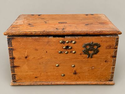 an old wooden box with a metal latch on the lid