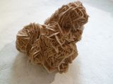 une petite peluche faite de nouilles posée sur une table