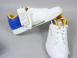 pair of white and blue tennis shoes with yellow laces on them
