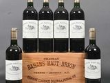 six bottles of red wine in a wooden crate on a table