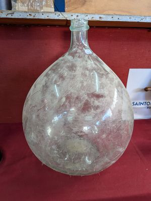un grand vase en verre posé sur un tissu rouge