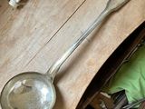 a spoon and a ladle sitting on a wooden table