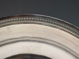 a close up of a silver plate with a clock on it