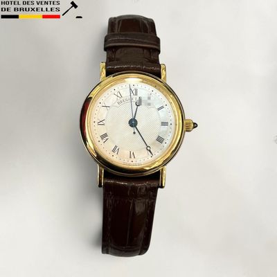une montre-bracelet en or avec des chiffres romains