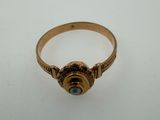 a close up of a gold ring with a stone in the center