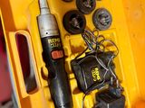 une boîte à outils jaune, contenant des outils, posée sur une table