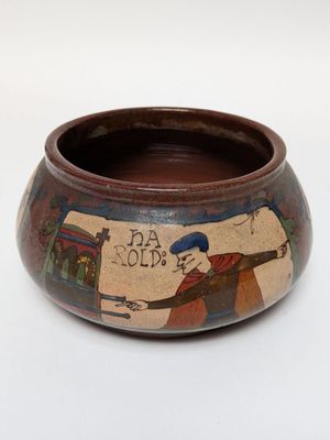 a small bowl with a painting on it on a white surface