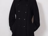 le mannequin porte un manteau et un chapeau noirs