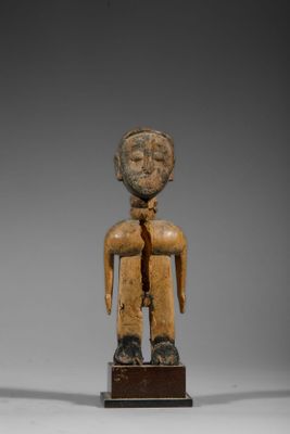 une figurine en bois représentant un homme avec une cravate sur la poitrine