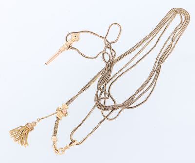 three gold necklaces with tassels and a key on a white background