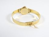 a close up of a gold bracelet with a clasp on a white surface