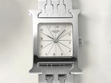 a close up of a silver watch on a white surface