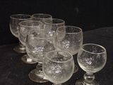 several empty wine glasses are lined up on a black surface