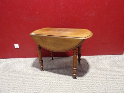 une photo représentant une petite table en bois avec un mur rouge en arrière-plan