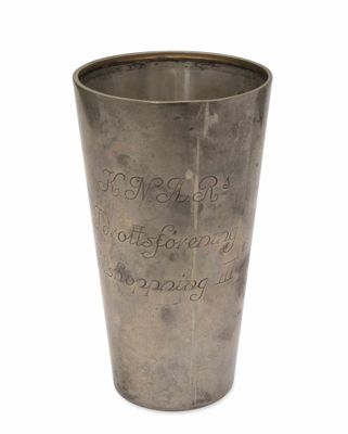 une tasse en métal portant une inscription sur un fond blanc