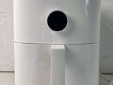 a white air fryer sitting on a counter next to a white wall