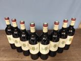 six bottles of red wine lined up on a wooden table