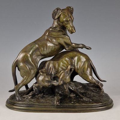 sculpture en bronze représentant un chien et un chat sur un rocher