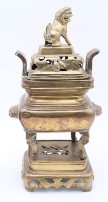 brass incense box with a bird on top of it on a stand