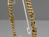 a close up of a gold bracelet on a clear stand