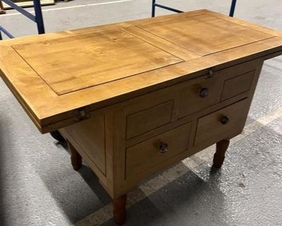 une table en bois munie de tiroirs, dans un entrepôt