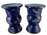 deux vases bleus ornés de fleurs sur fond blanc