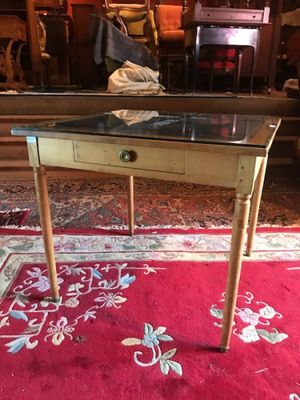 a small table with a glass top on a red rug